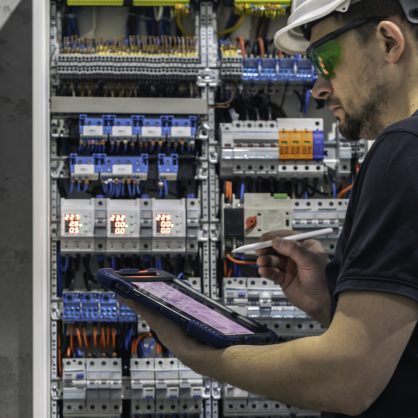 un-electricien-travaillant-dans-un-central-electrique-avec-des-fusibles-utilise-une-tablette